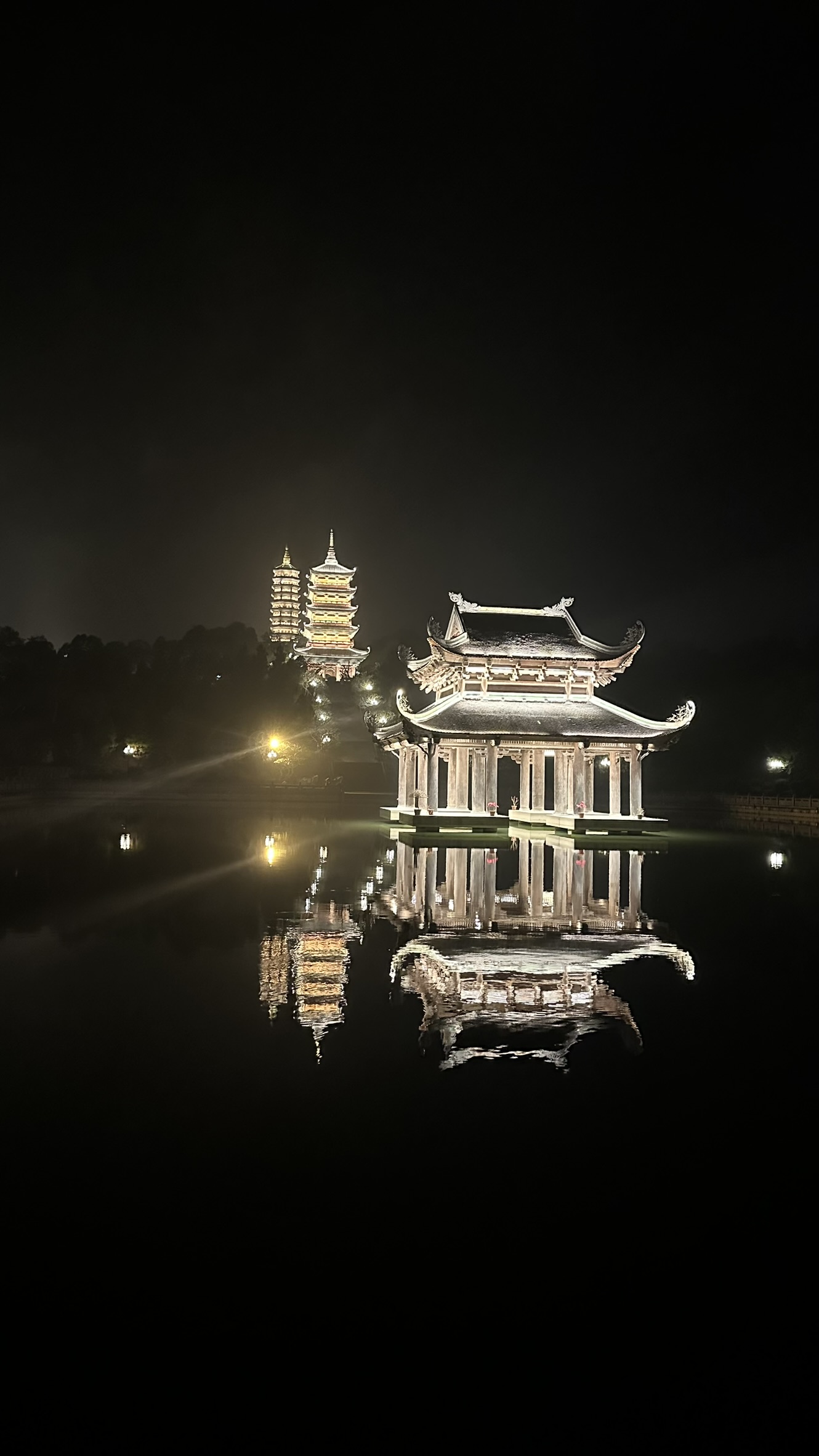 Golden lights illuminating the entrance of Bai Dinh at night